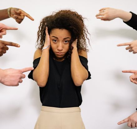 People Pointing Fingers at a Stressed Woman